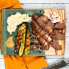 Smoked Beef Brisket on a platter with grilled veggies and mustard